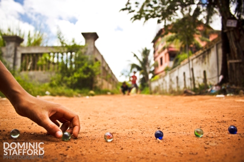 boy children play marbles game siem reap cambodia photography